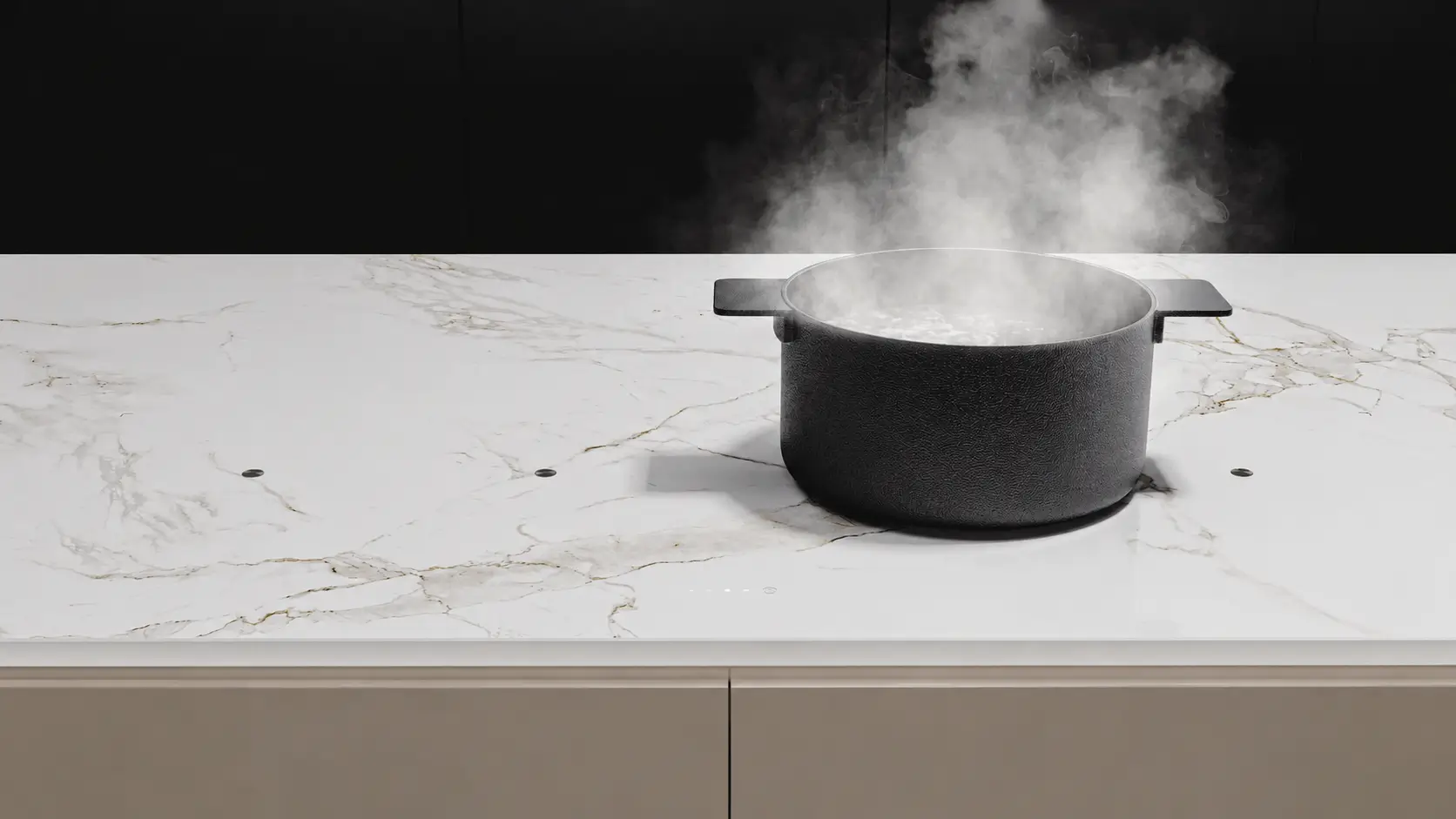 A steaming pot resting directly on the seamless Dekton stone worktop, where the induction surface is built into the stone itself