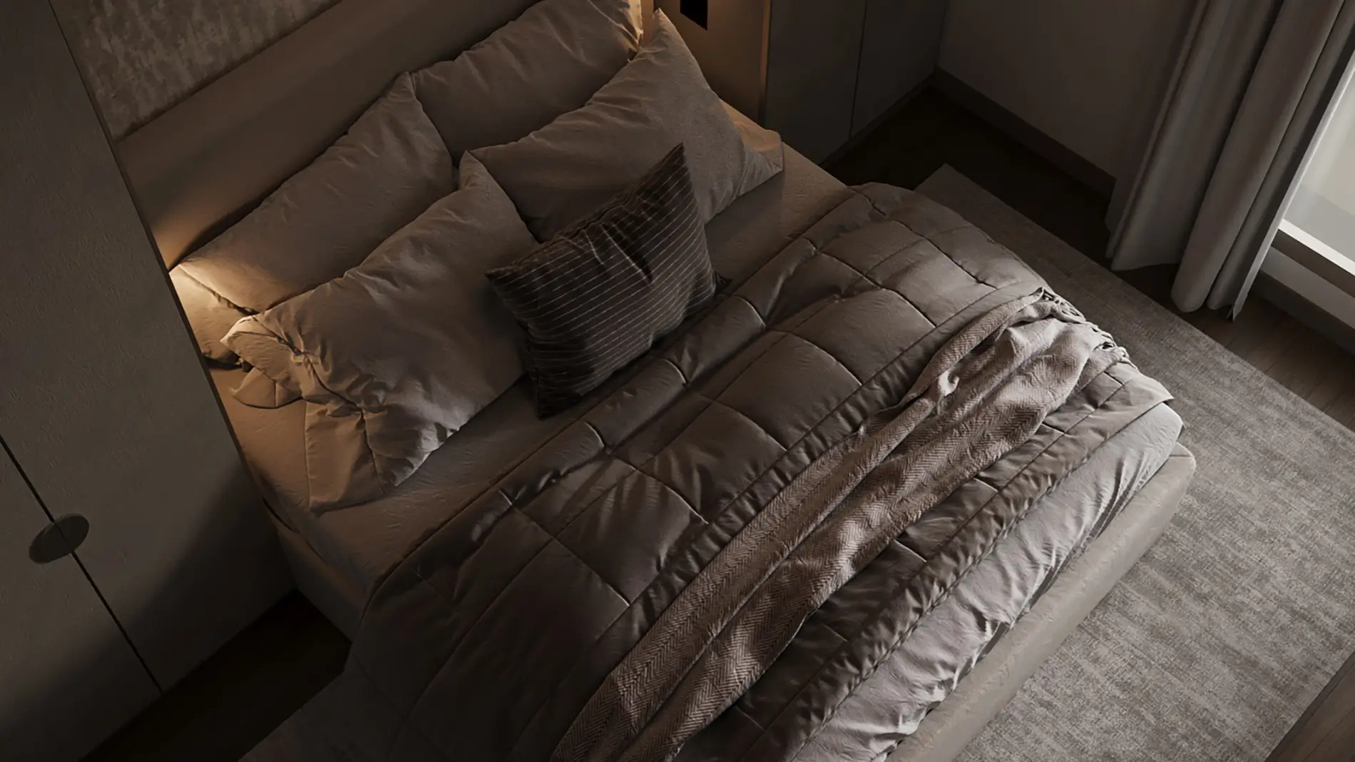 Close-up of the made guest bed with layered taupe bedding and a striped cushion under soft headboard lighting