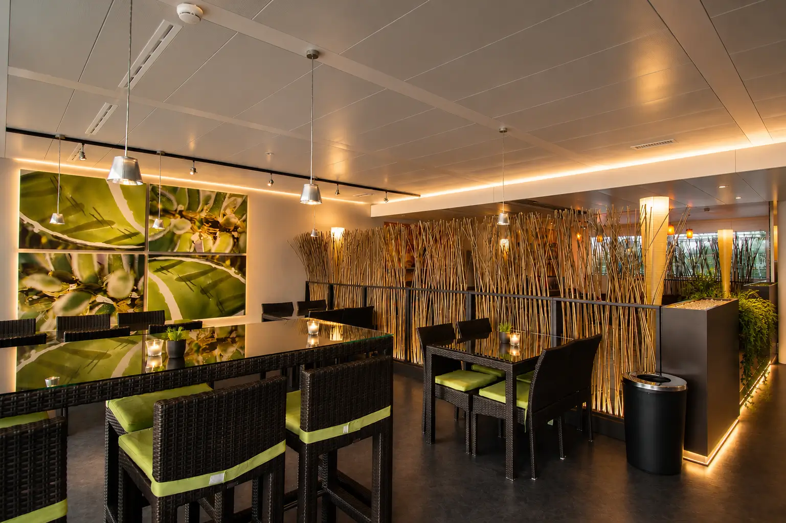 Cafeteria with ribbed orange counter tables, white bar stools and Logitech wall graphic by the windows