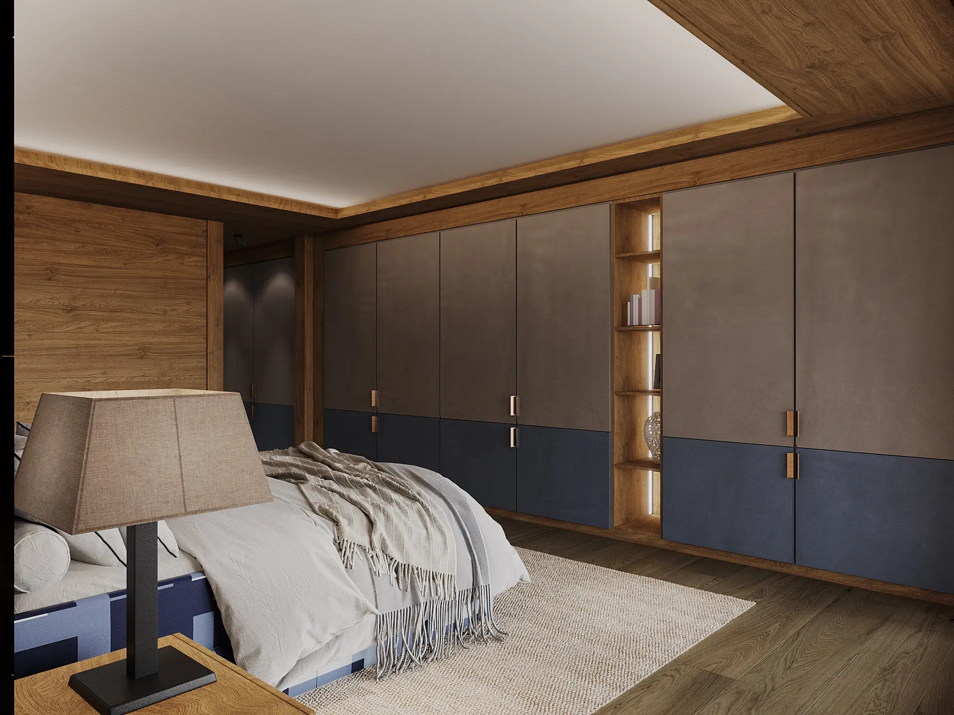 Bedroom with a low upholstered bed, woven table lamp and a wall of muted leather and navy wardrobes with a backlit open shelving niche