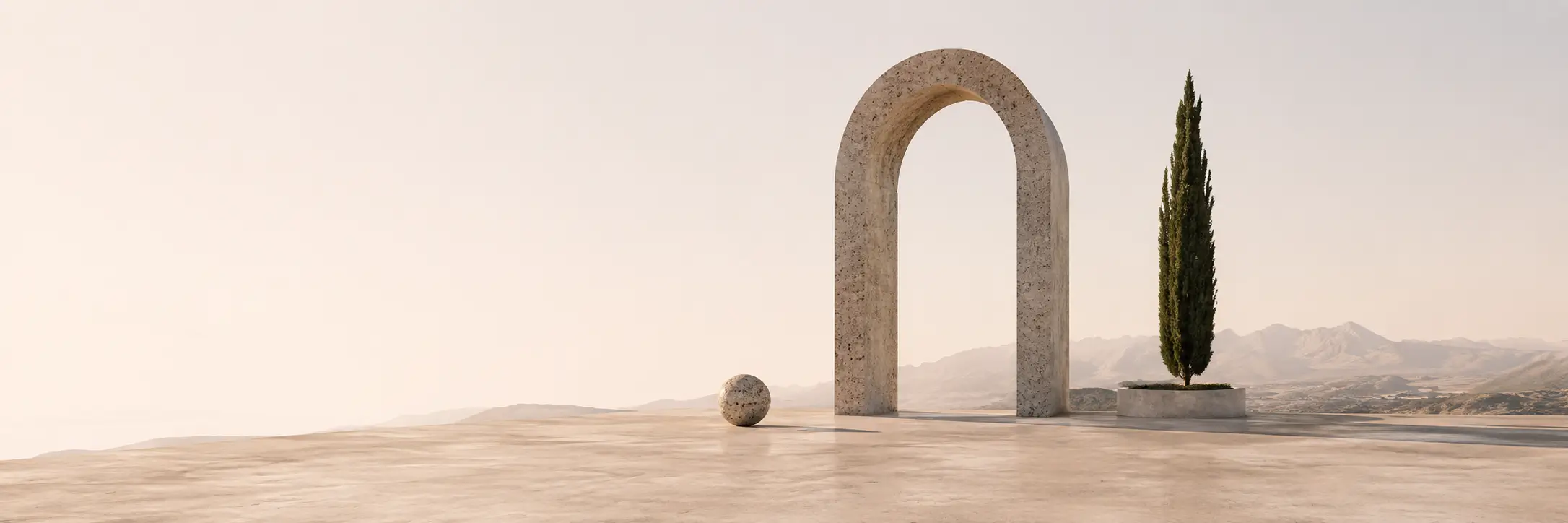 Travertine arch and a stone sphere on an open plaza, a cypress tree and mountain ridge beyond