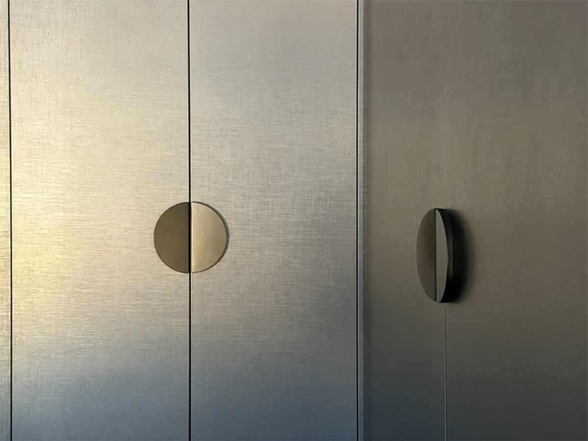 Bespoke wardrobe joinery detail with circular brass handles